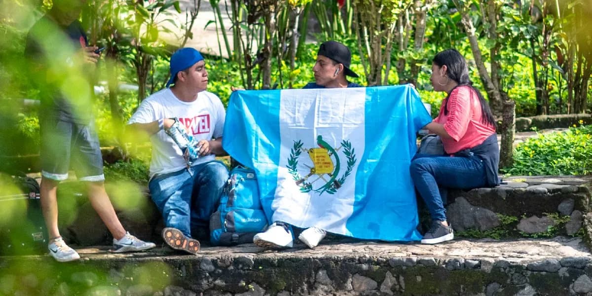 Grupo de amigos con la bandera de Guatemala en las áreas verdes del parque