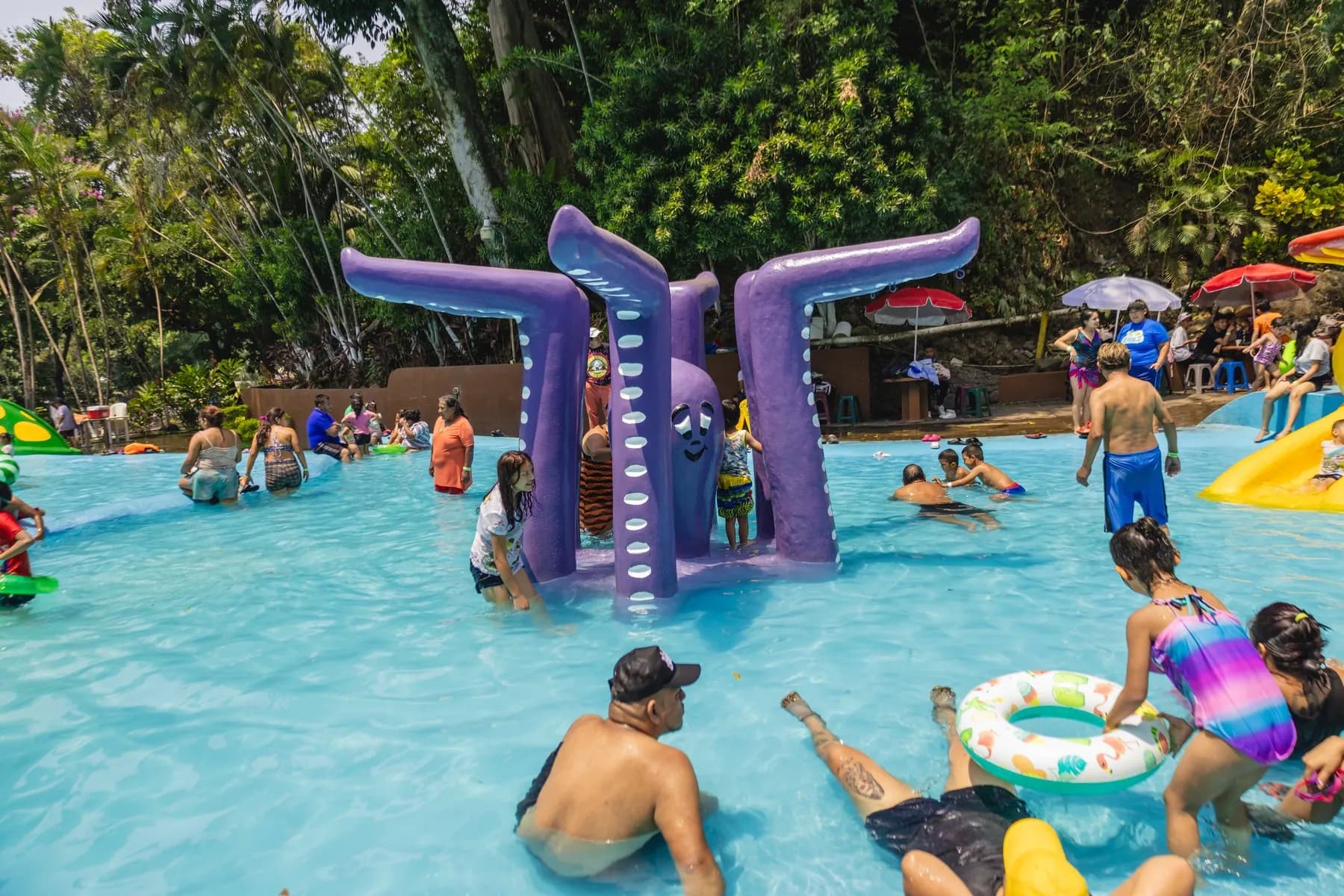 Niños jugando junto al pulpo morado en la piscina de niños